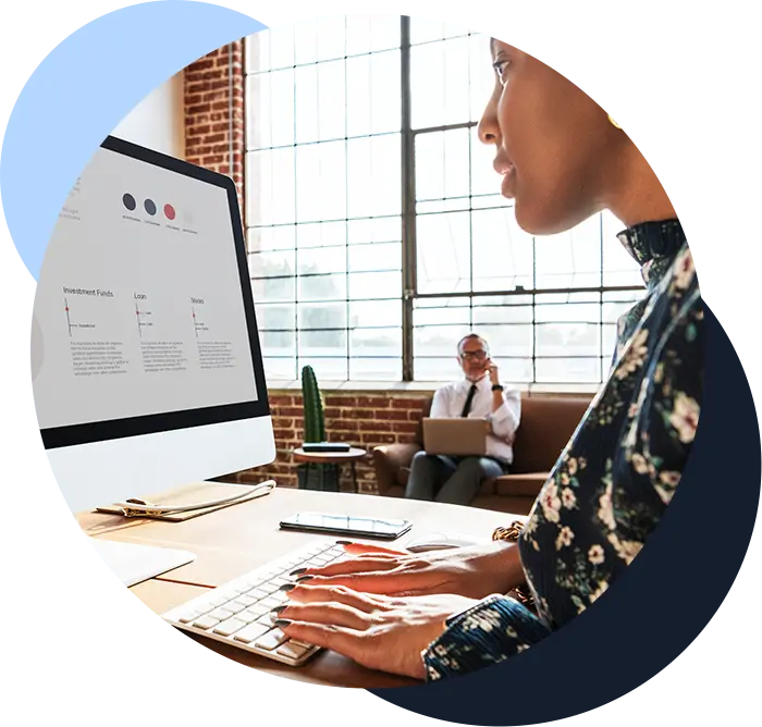 Color image of and employee typing on a desktop computer that is pulling information and data from multiple systems into one spot