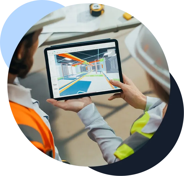 Two construction workers look at a schematic on a tablet in a construction site