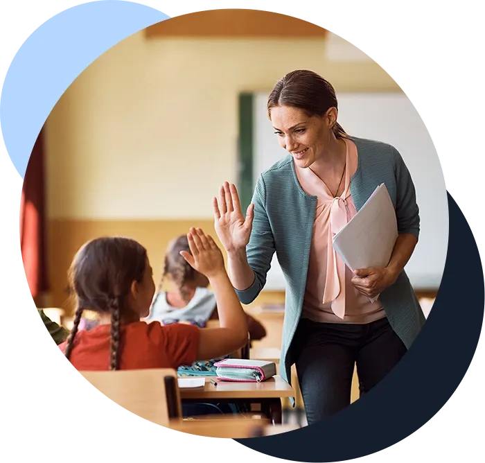 Teacher and student high-five in a classroom setting